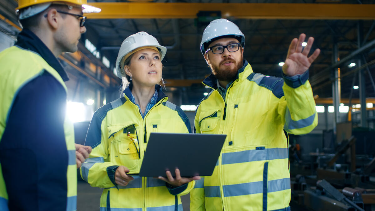 Male and female engineers conversing with a laptop