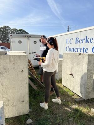 Alan Barr instructing Dominic Pina how to drill into concrete