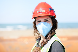 Woman wearing safety helmet and mask